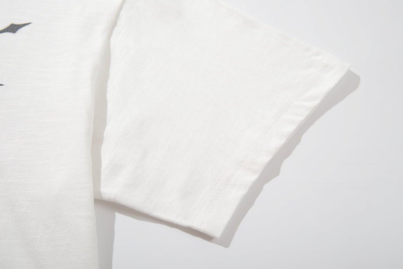 White cotton streetwear tee with a relaxed sleeve, subtle graphic detail, and minimalist clean design