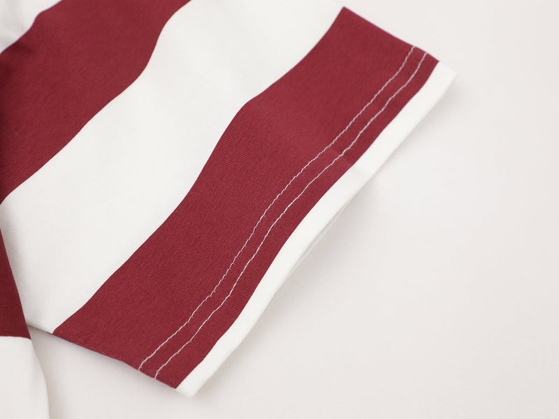 Close-up of oversized burgundy and white striped tee sleeve with visible contrast stitching on soft cotton fabric