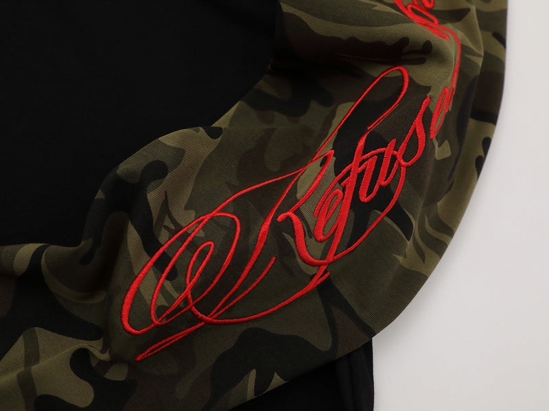 Close-up of camouflage sleeve with red embroidered script on black raglan tee
