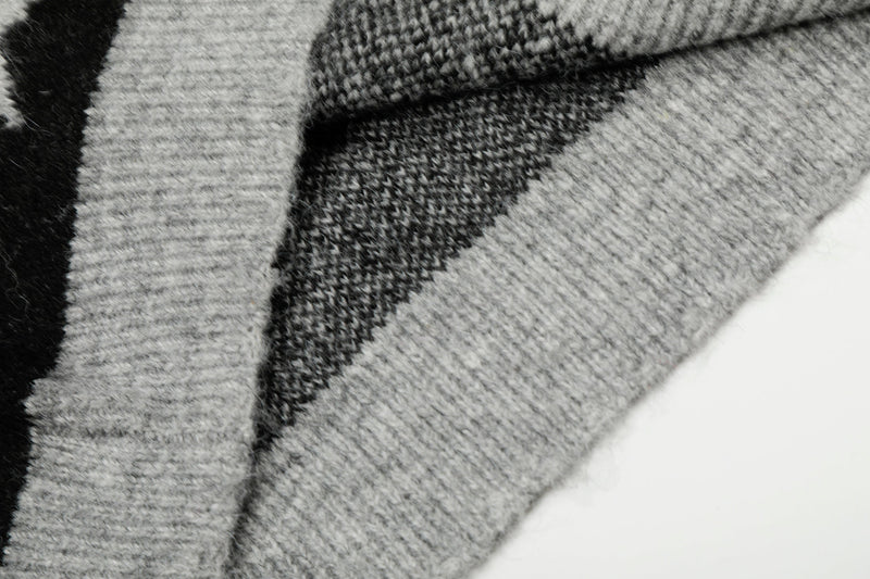 Close-up of knit fabric texture on black and gray star sweater