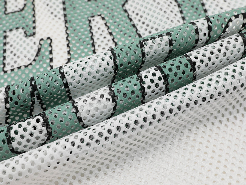 Close-up of mint green and white mesh jersey fabric with bold black varsity lettering detail