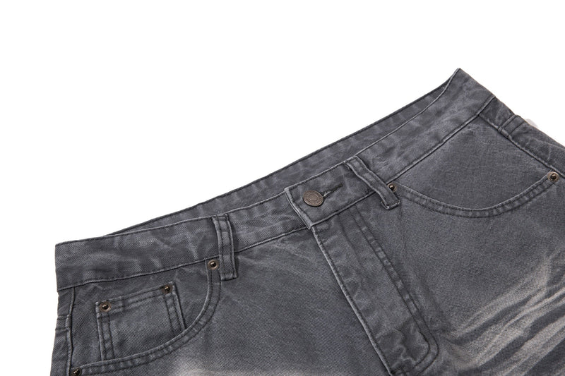 Close-up of charcoal denim waistband, button closure, belt loops, and front pocket