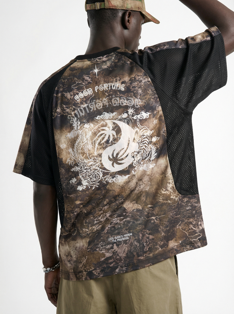 Man wearing a desert camo mesh performance tee with bold back graphic and black sleeves, shown from the back