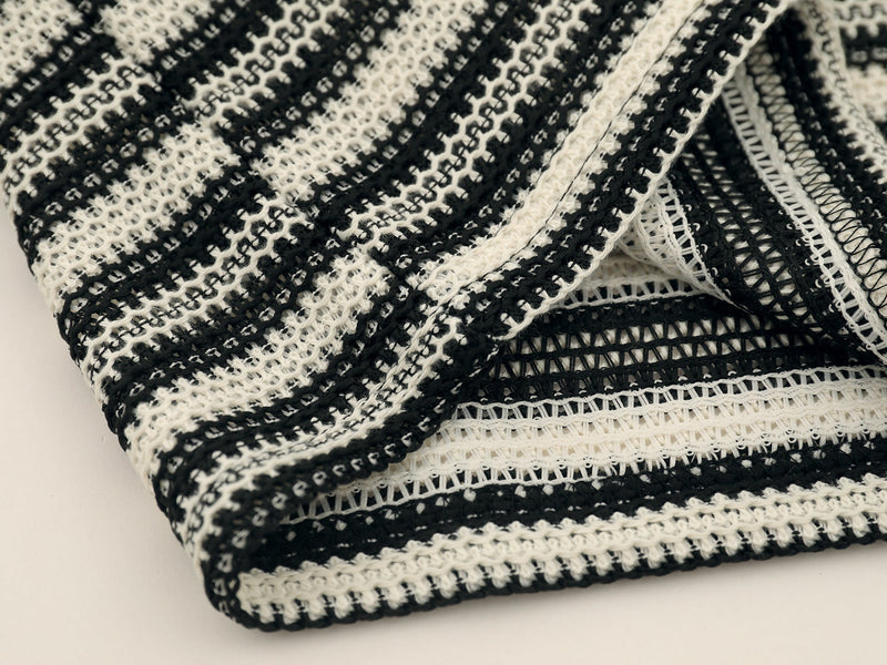 Close-up of black and cream striped knit hem with layered edge detail