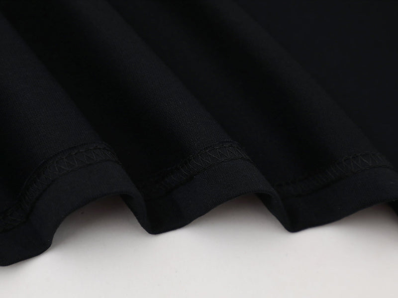 Close-up of black sleeve cuffs and hem stitching on soft knit fabric