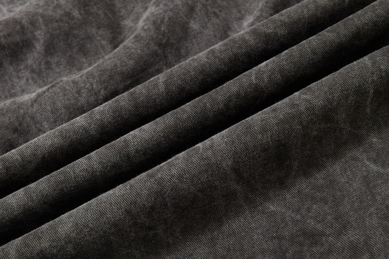 Dark charcoal denim fabric close-up with soft washed texture and ribbed twill weave