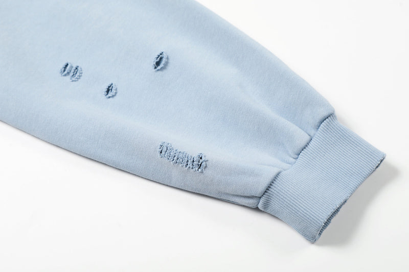 Close-up of light blue hoodie cuff and sleeve distressing
