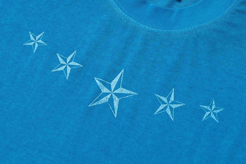 Blue oversized vintage wash cotton tee with a ribbed collar and scattered white star graphics across the chest