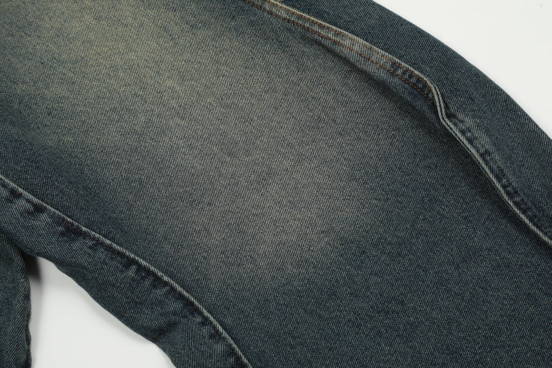 Close-up of wide-leg denim fabric with faded wash and side seam