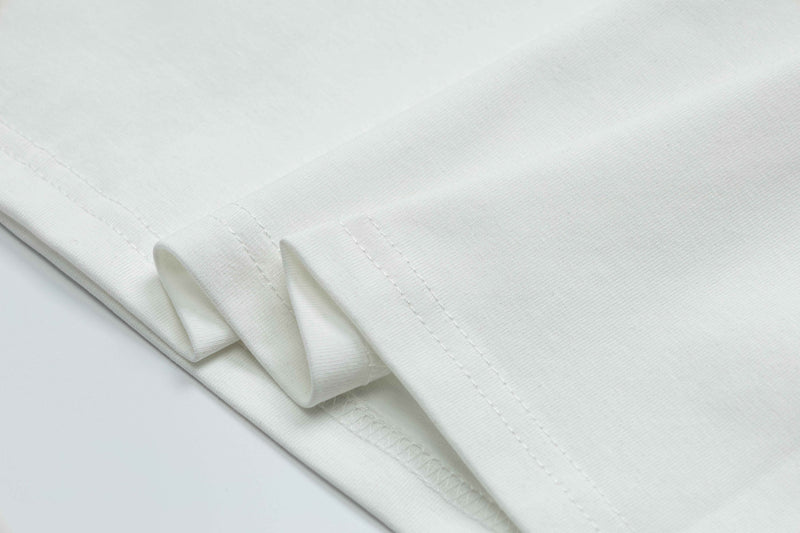 Folded white graphic T-shirt with visible hem stitching and smooth cotton fabric texture