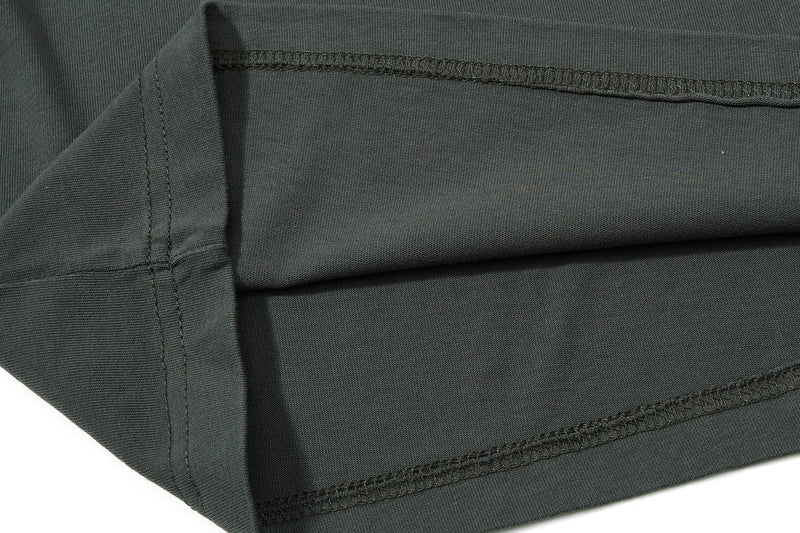 Close-up of dark olive cotton polo tee fabric with visible collar stitching and hem details