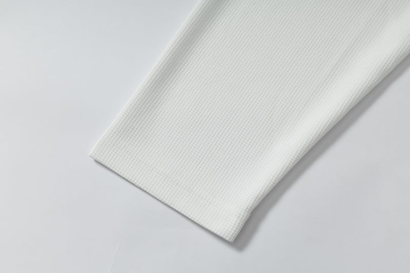 Close-up of plain white long-sleeve sleeve cuff with textured fabric