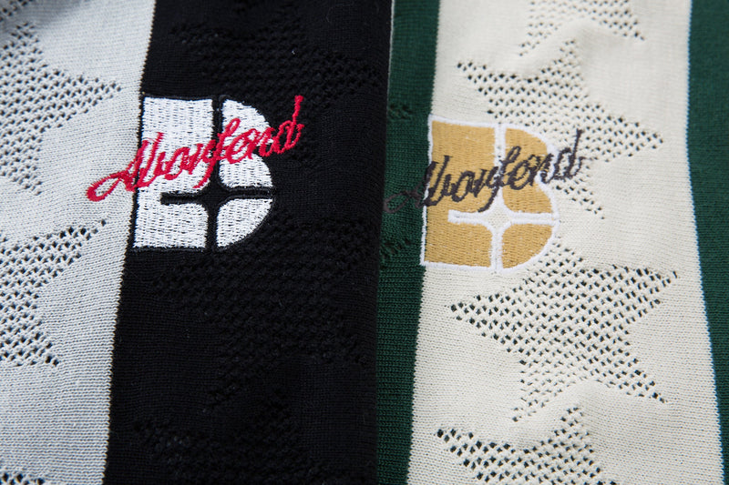Close-up of front chest embroidery on black and cream striped knit polo shirt
