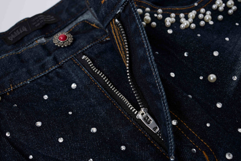 Close-up of black denim waistband and zipper with pearl studs