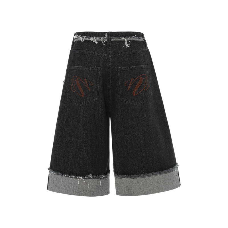 Back view of black wide-leg denim shorts with back pockets, red embroidery, and cuffed hems