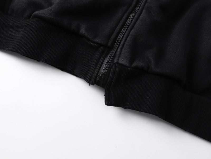 Close-up of black zip hoodie hem with ribbed cuff and front zipper detail
