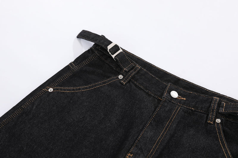 Close-up of black denim shorts front waistband with metal buckle and top stitching