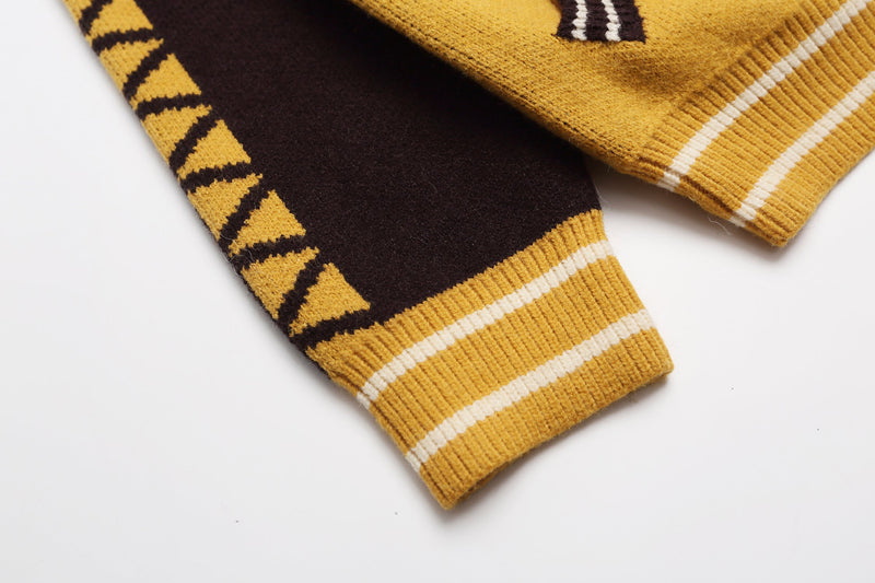 Close-up of yellow ribbed cuff and black sleeve with triangle pattern