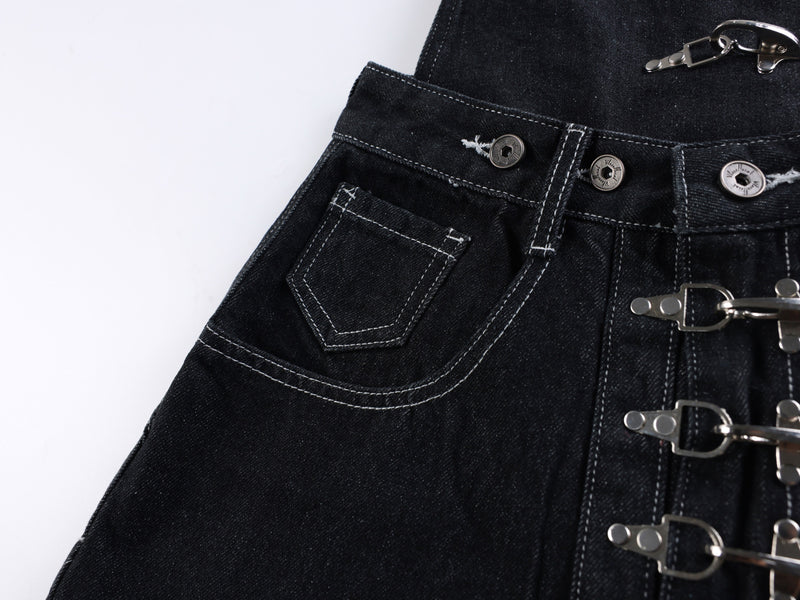 Close-up of black jeans front pocket and waistband with metal buttons and buckle hardware