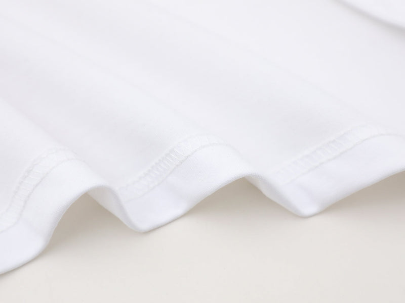 Close-up of white sleeve hem with stitching and folded cuff detail