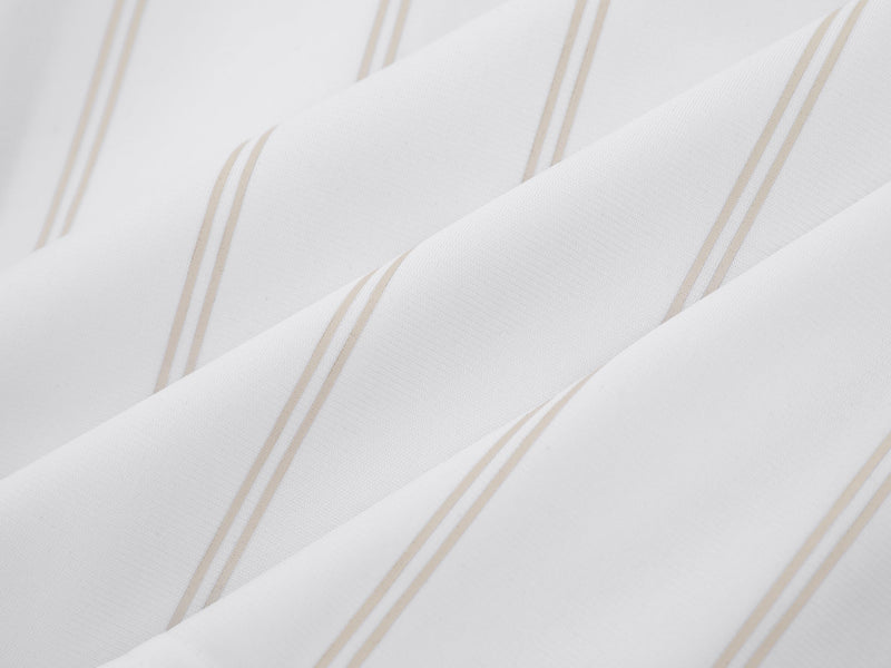 Close-up of white jersey fabric with thin beige pinstripes and soft folds