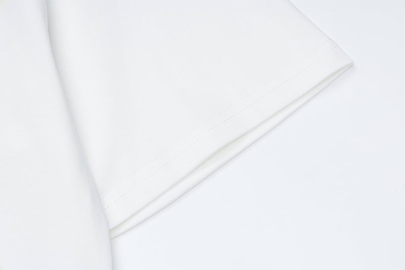White graphic tee sleeve and hem detail with clean seam on a minimalist background