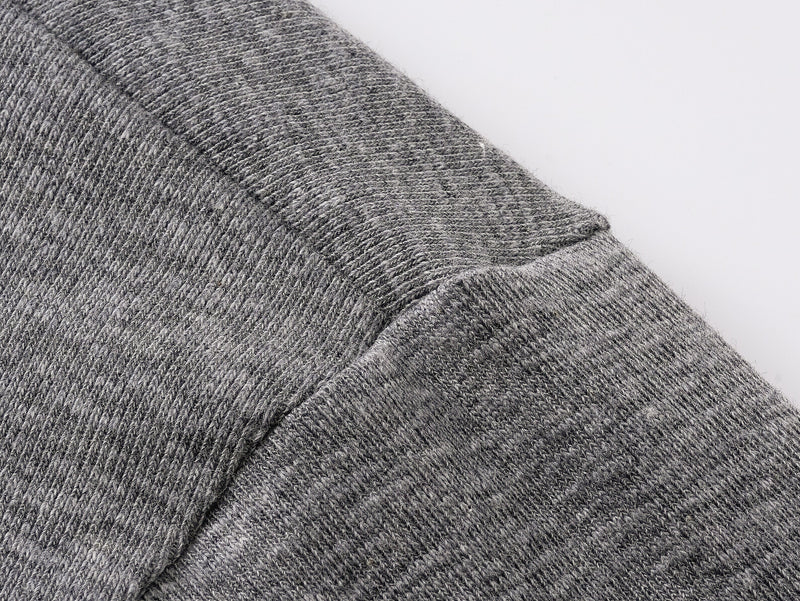 Close-up of gray tee sleeve and shoulder seam with heathered knit texture