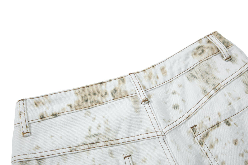 Close-up of back waistband on white splatter-wash denim with stitched seam detail