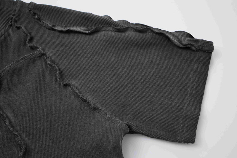 Black ribbed compression tee with raw seam paneling and frayed deconstructed streetwear detail