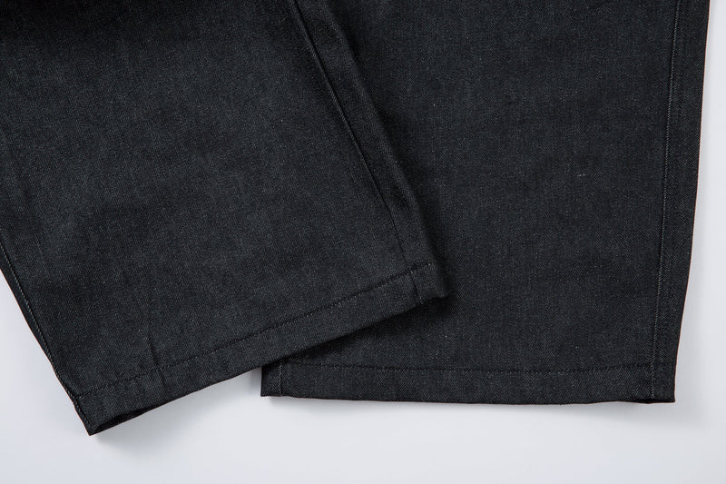 Close-up of the wide hem and side seam on dark denim pants