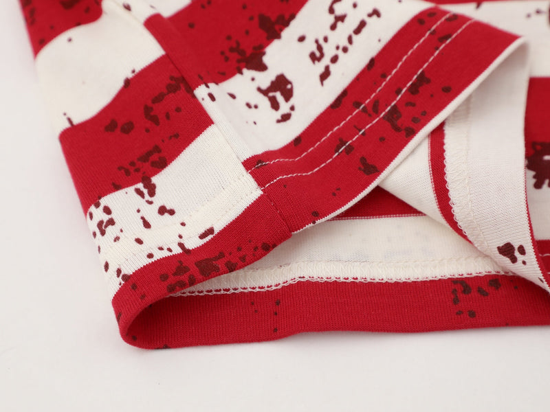 Close-up of cream tee folded hem showing red striped fabric and stitching