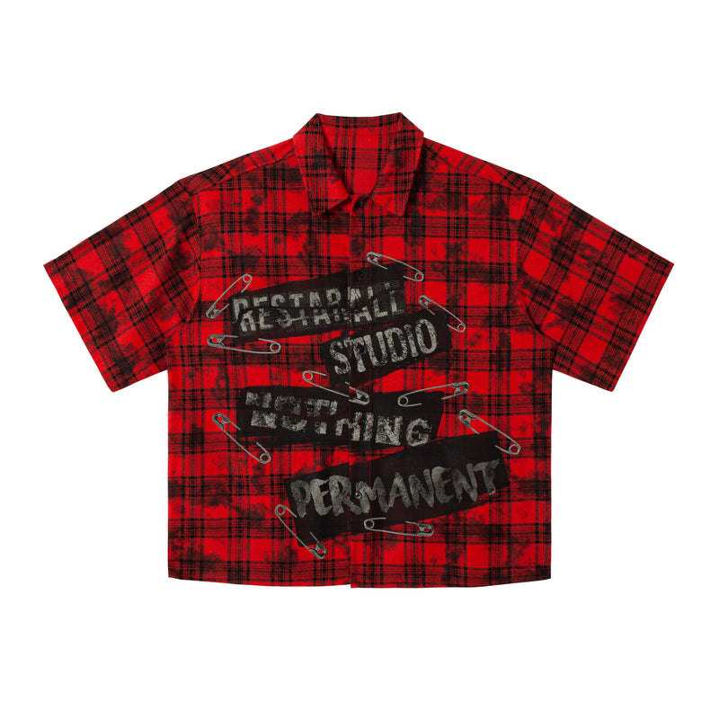 Red and black plaid cropped button-up shirt with punk graphic print and safety pin design, front view