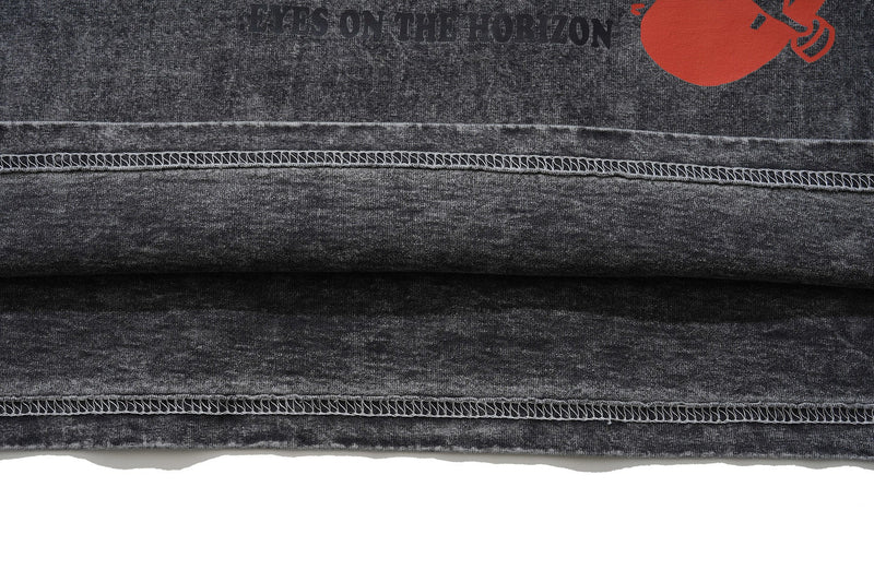 Close-up of a vintage wash black skate graphic tee with raw hem and red Eyes on the Horizon print