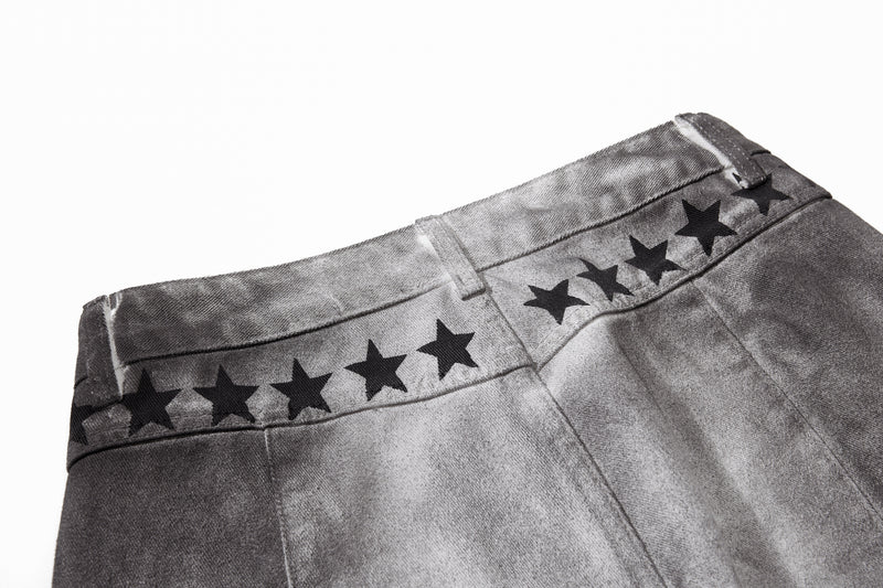 Close-up of waistband back with black star print across the yoke on gray washed denim