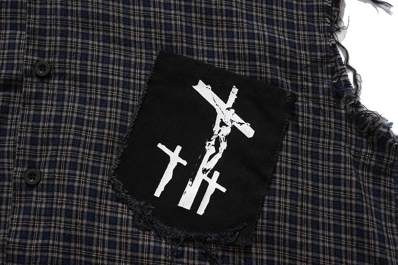 Close-up of black chest patch with white graphic on dark plaid shirt