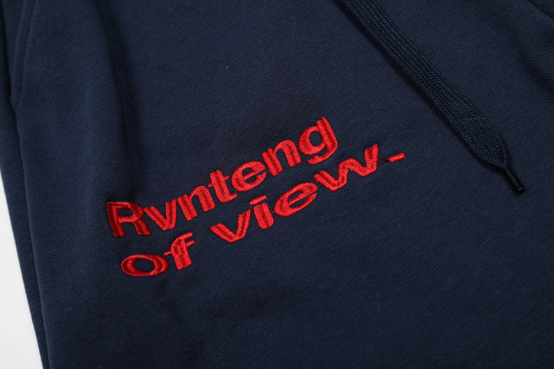 Close-up of red embroidered front text on navy shorts with drawstring