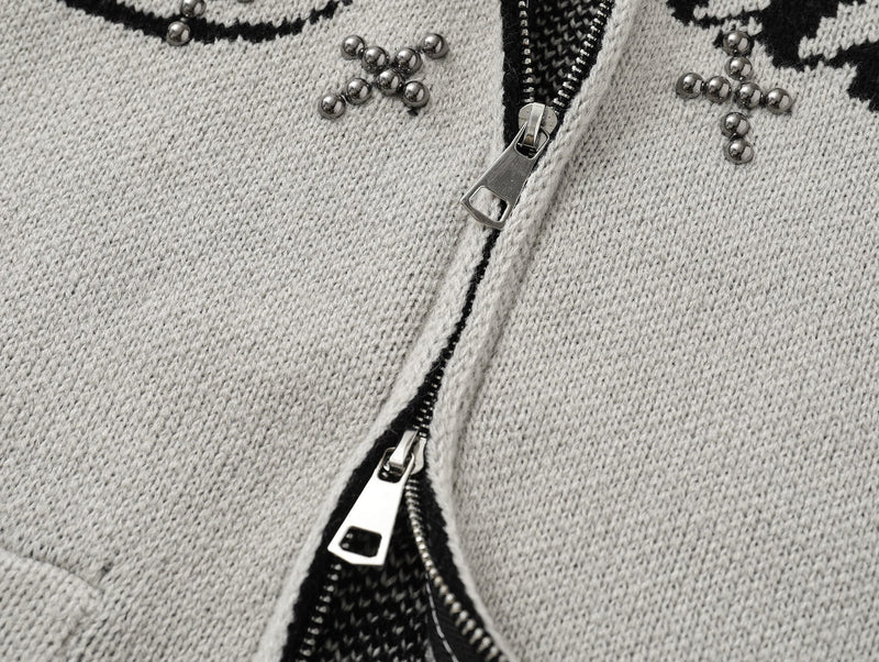 Close-up of light gray cardigan zipper with studded bead accents near the chest