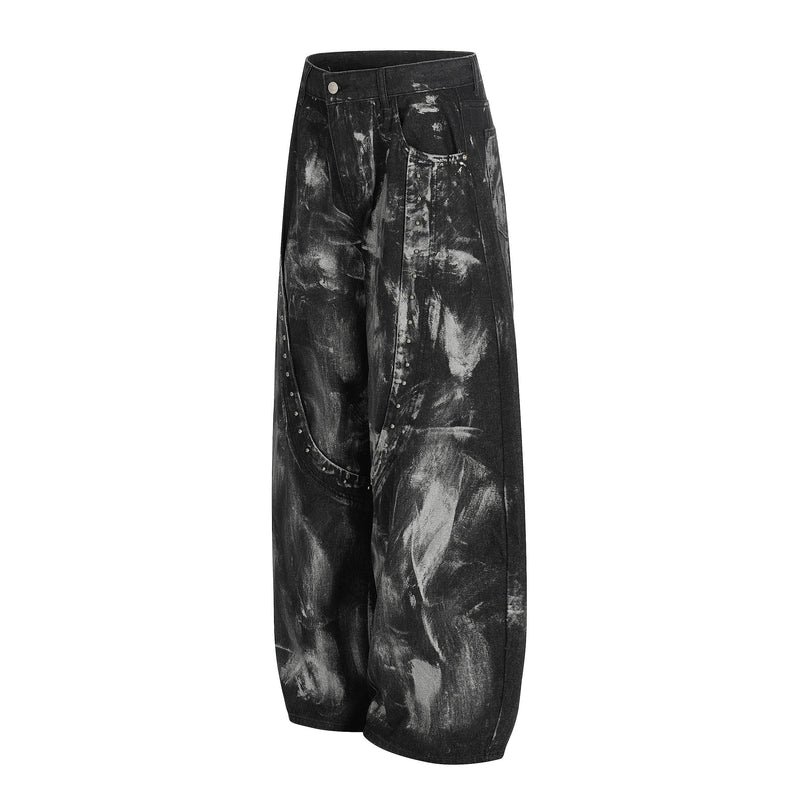 Angled front view of black painted wide-leg jeans with studded curved seam detailing