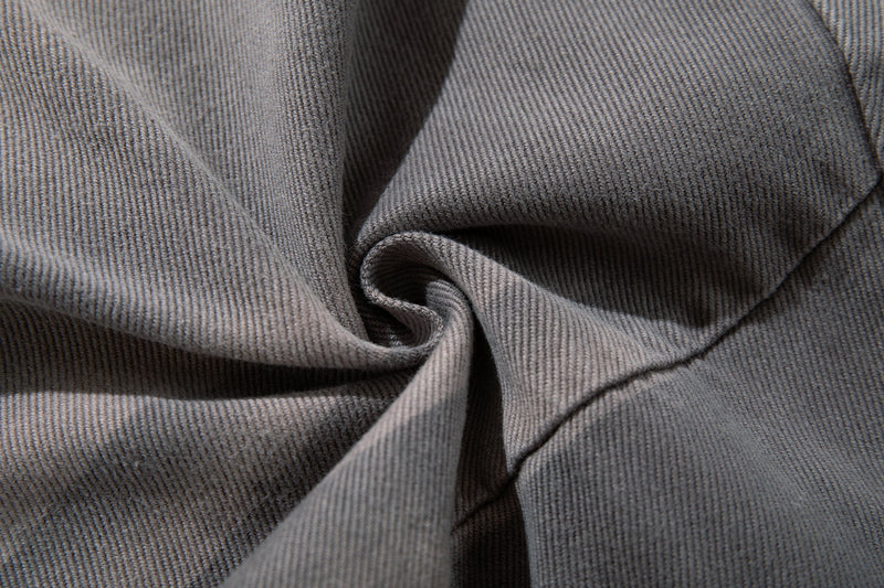 Close-up of gray jeans fabric folds and textured denim weave