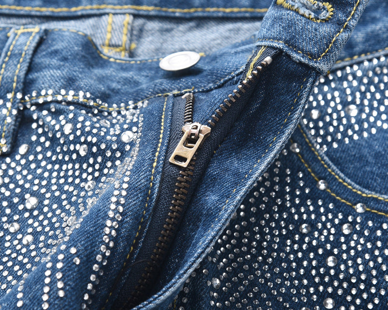 Close-up of blue denim zipper fly and front waistband with rhinestones