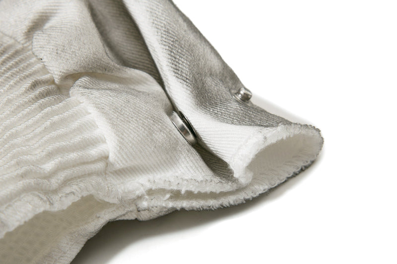 Close-up of the cuffed hem and side snap on light gray denim shorts