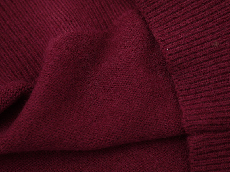 Close-up of burgundy knit fabric texture with ribbed cuff detail
