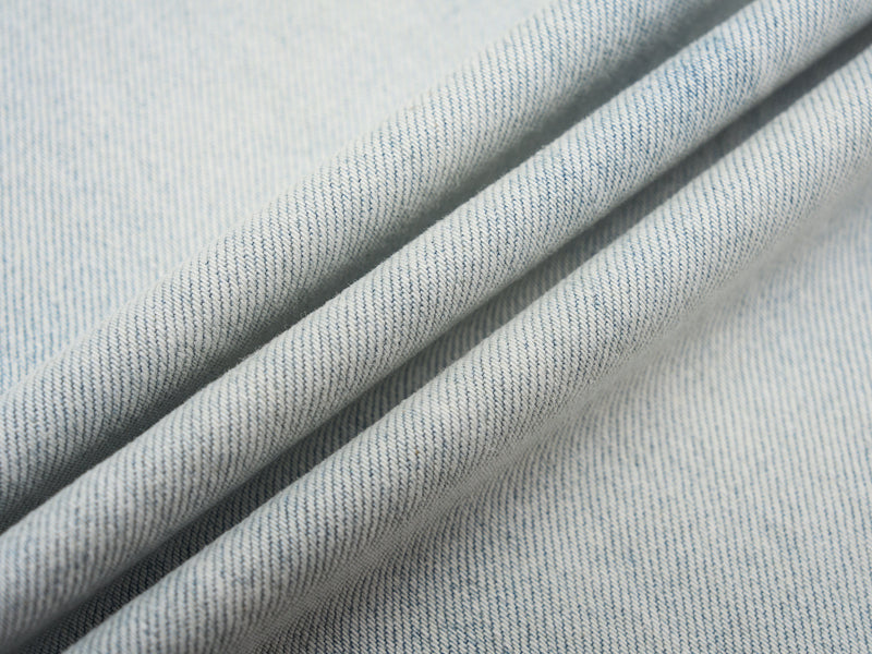 Close-up of light wash denim fabric with soft folded texture