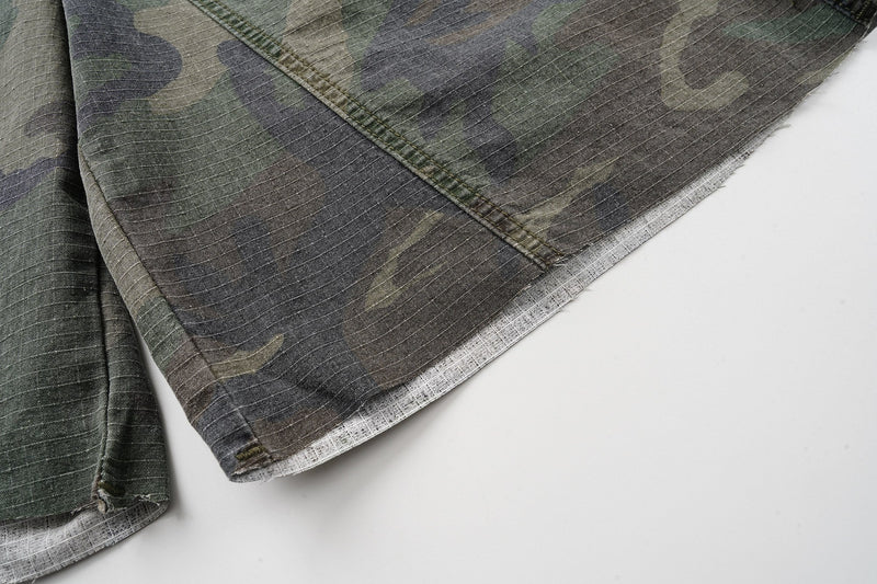 Close-up of the wide leg hem and light inner lining on camouflage cargo shorts