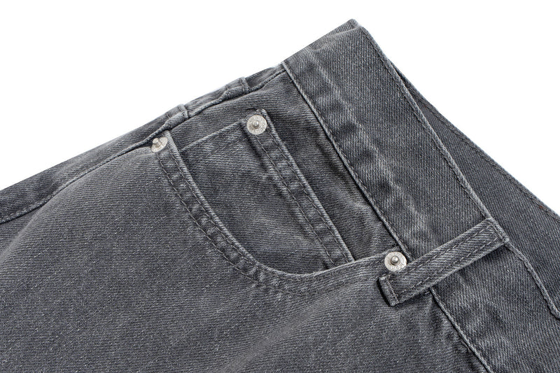 Close-up of front waistband on grey denim pants with button fly and coin pocket