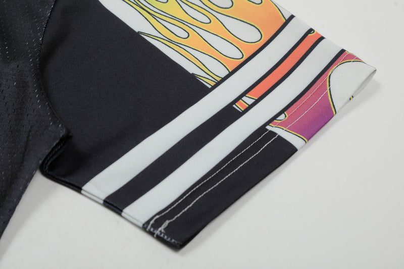 Close-up of a black football jersey sleeve with rainbow flame graphic, white stripes, and stitched hem detailing