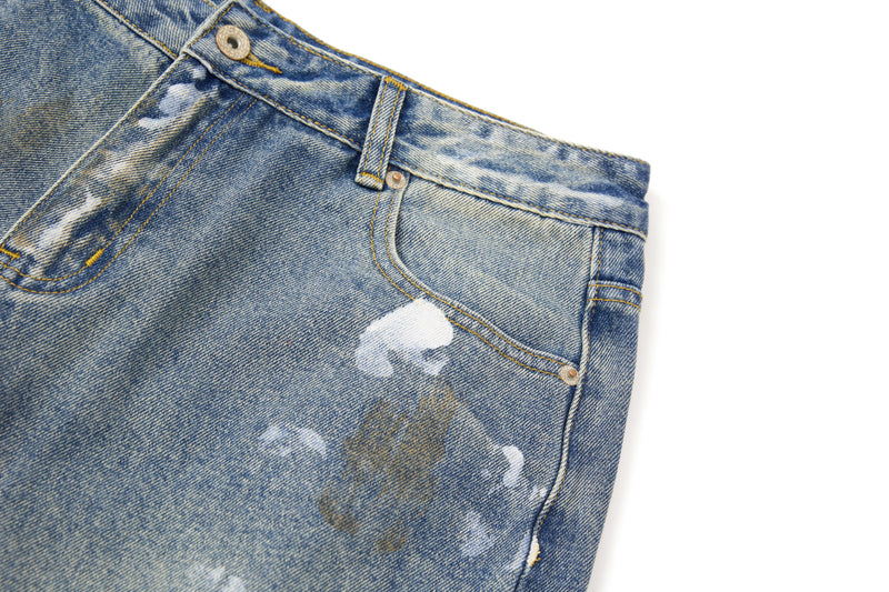 Close-up of front pocket and waistband on faded distressed denim pants