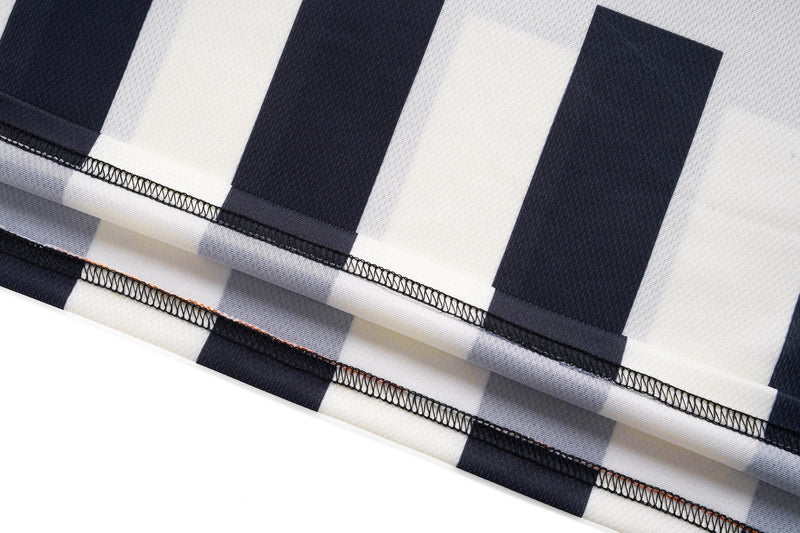 Close-up of folded black and white striped soccer jersey fabric with visible stitching and retro varsity style