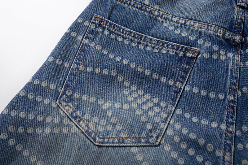 Close-up of back pocket on blue washed denim pants with dotted print