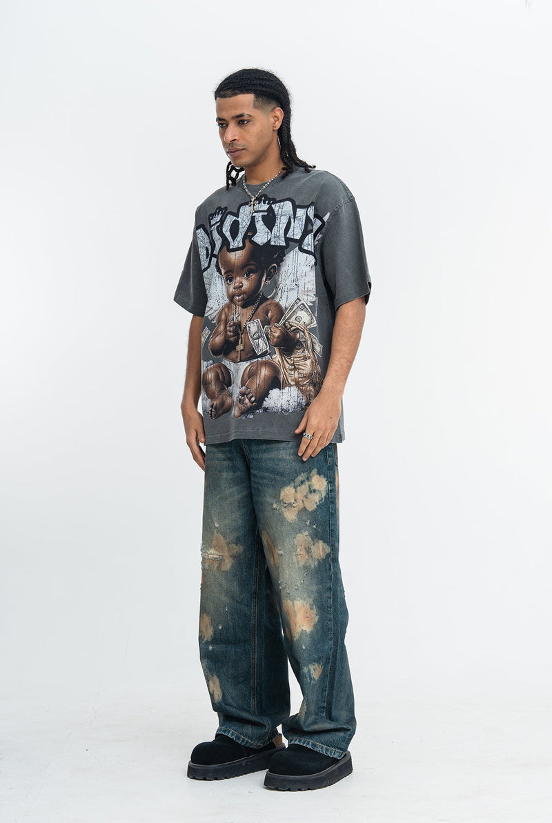 Model wearing a vintage wash graphic T-shirt with baby artwork, baggy faded jeans, and black shoes on a white background